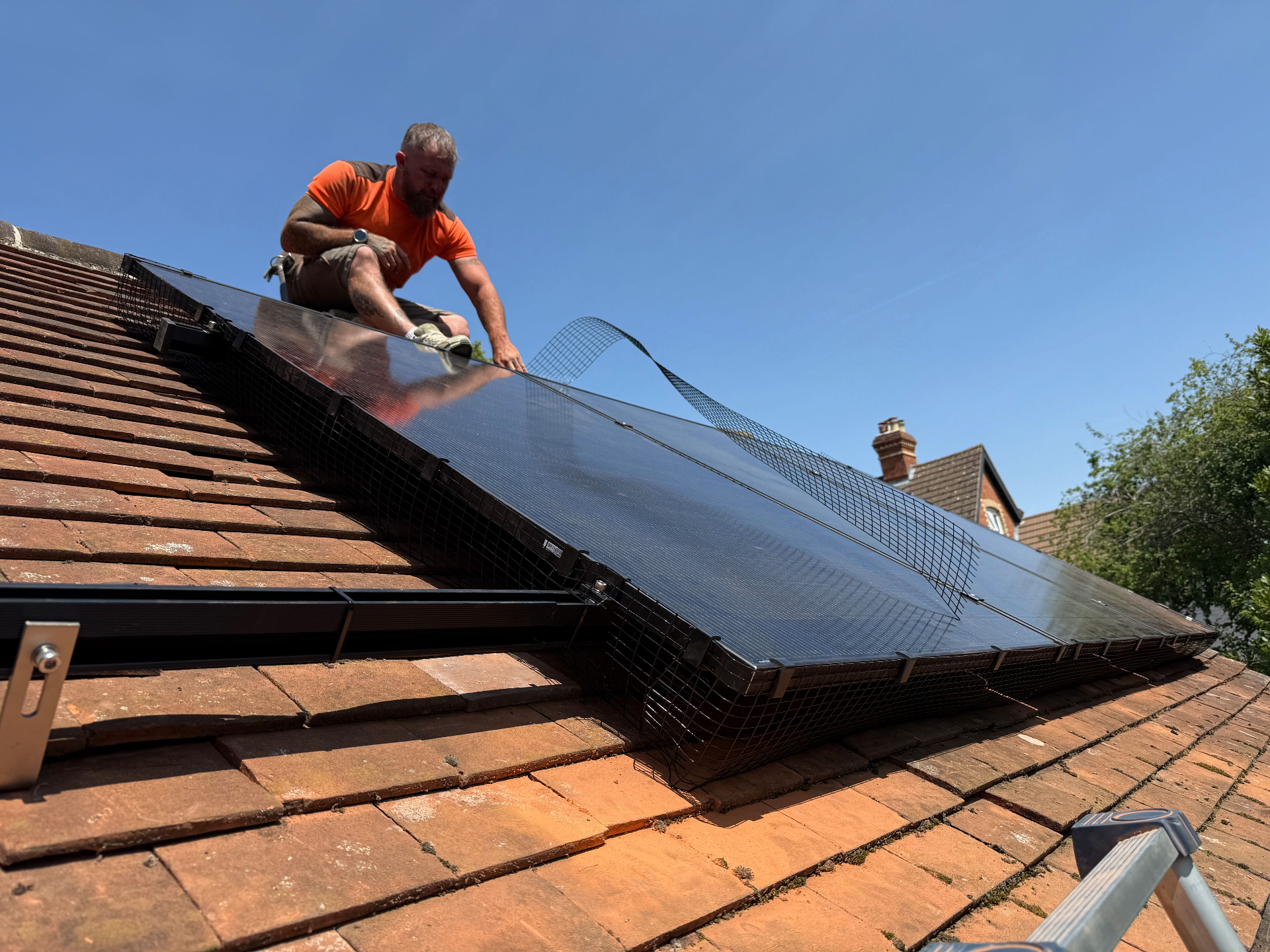 Roofer fitting one of three JA Solar 460W panels on my extension roof
